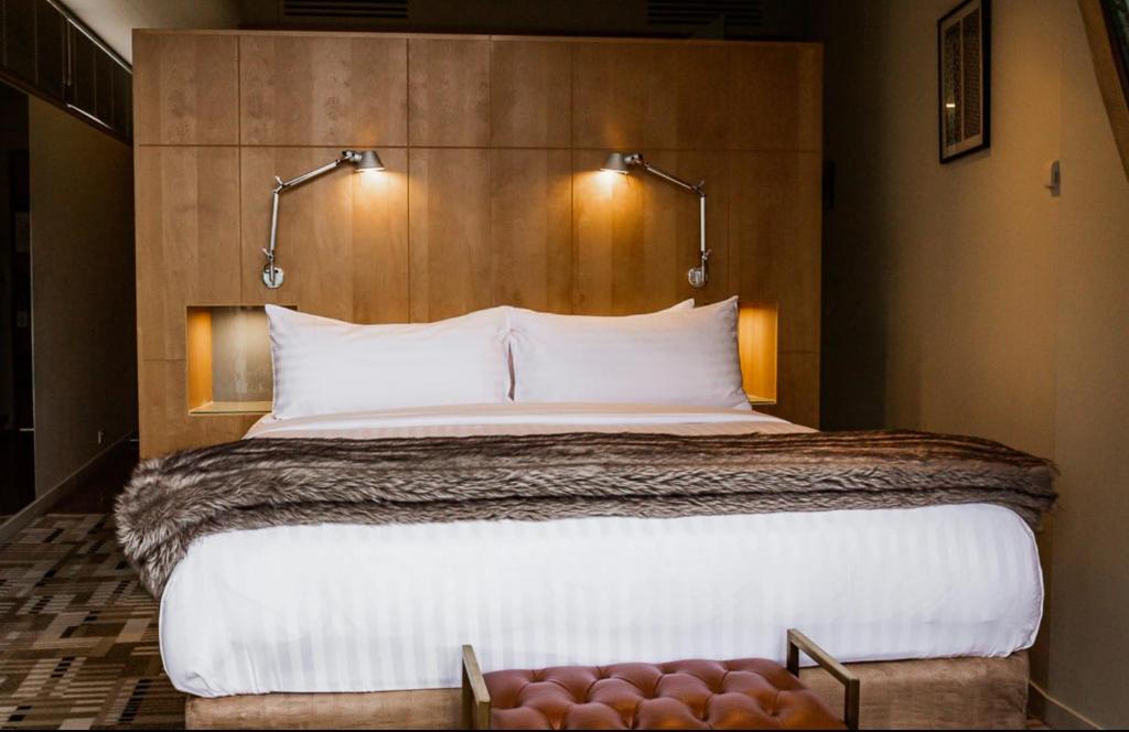 a bedroom with a large bed with two lights above it at Islington Hobart - Wellington Suite - Australia in Hobart