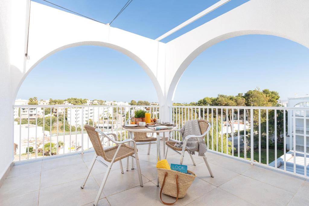 eine Terrasse mit einem Tisch und Stühlen auf dem Balkon in der Unterkunft Apartamentos Ferrera Pins in Cala Ferrera