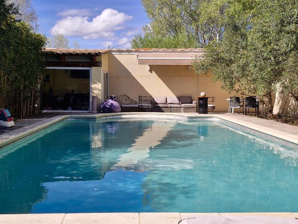una piscina de agua azul en un patio en La maison champêtre - Rendez-vous en Provence, en Althen-des-Paluds