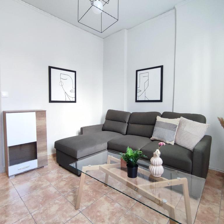 uma sala de estar com um sofá e uma mesa em Madi01 em Atenas