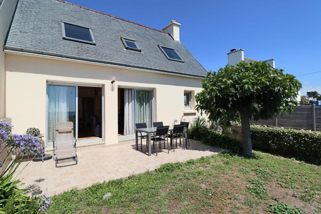 a patio with chairs and a table in front of a house at 605 VIlla ocean Atlantique au bout du jardin in Audierne