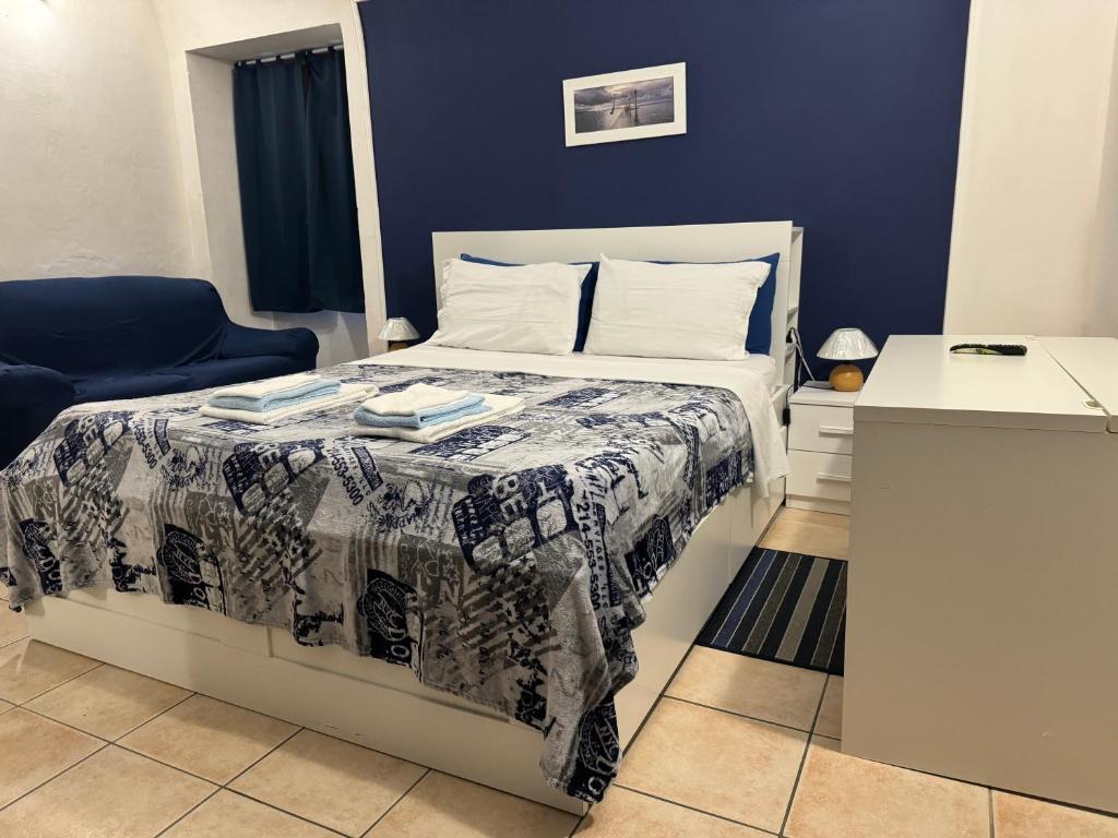een slaapkamer met een bed en een blauwe muur bij Intero alloggio: appartamento bilocale in Alessandria
