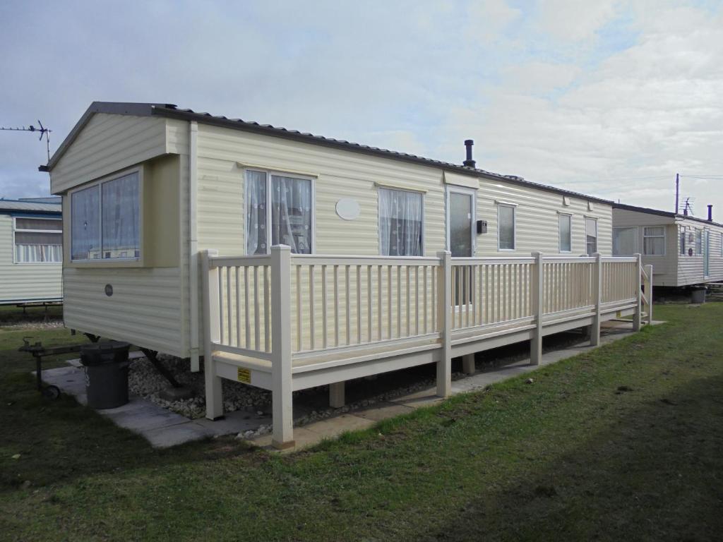 a white mobile home with a fence around it at 8 Berth Coral Beach (Mirage Super) in Ingoldmells