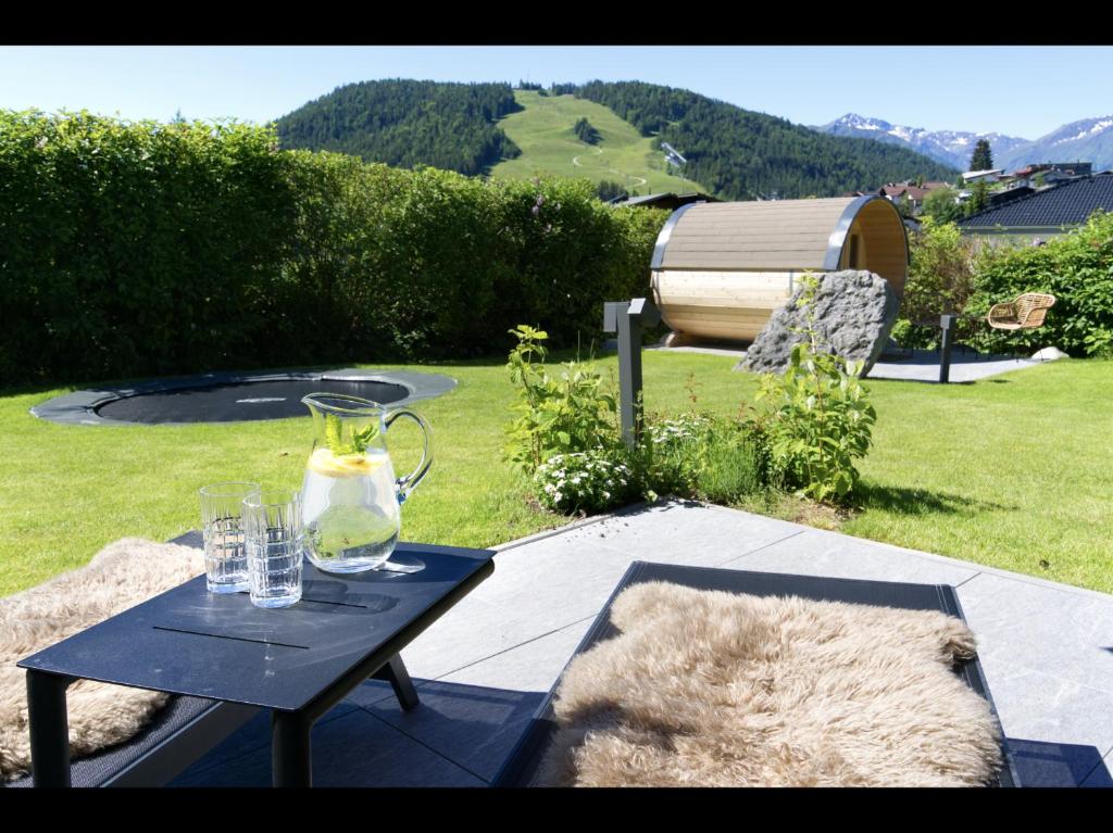 una mesa con un jarrón y gafas. en Villa Mama - Luxus und Lebensfreude, en Seefeld in Tirol