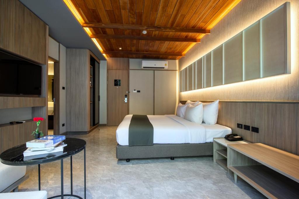 una habitación de hotel con una cama y una mesa en Luminous Resort & Spa by Areca, en Phuket