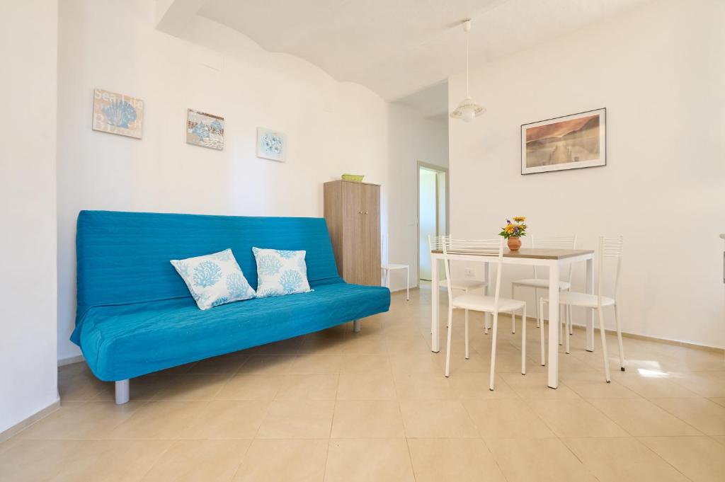ein blaues Sofa im Wohnzimmer mit einem Tisch in der Unterkunft Mare Etrusco 8 in Populonia