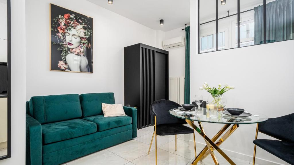 a living room with a green couch and a table at Widok Apartments, Sun & Snow in Warsaw