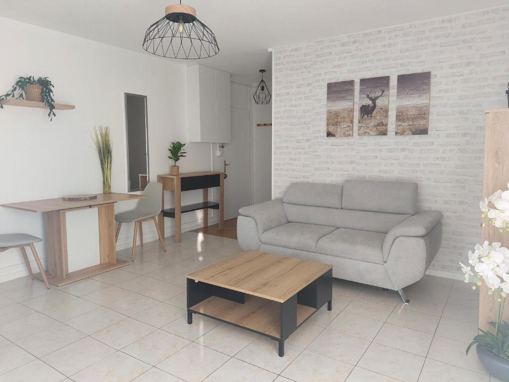 een woonkamer met een bank en een tafel bij l' Iris in Orvault