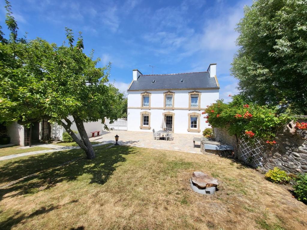 ein großes weißes Haus mit einem Baum im Hof in der Unterkunft 680-Villa Kerven-Pors Tarz in Primelin
