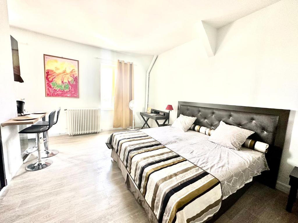 ein Schlafzimmer mit einem großen Bett und einer gestreiften Decke in der Unterkunft Vivre la vie de château in Amboise
