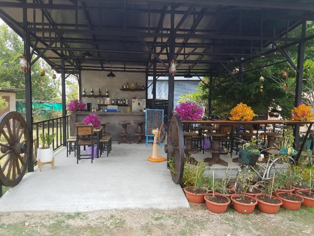 un pabellón con mesa, sillas y macetas en Paradise Hill en Chiang Dao