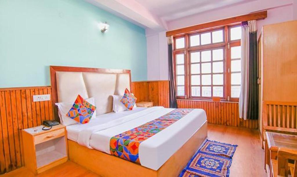 um quarto com uma cama grande e uma janela em FabHotel Kundan Inn em Manali