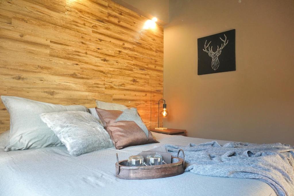 ein Schlafzimmer mit einem Bett mit einer Holzwand in der Unterkunft L'Alberghetto in Trinità