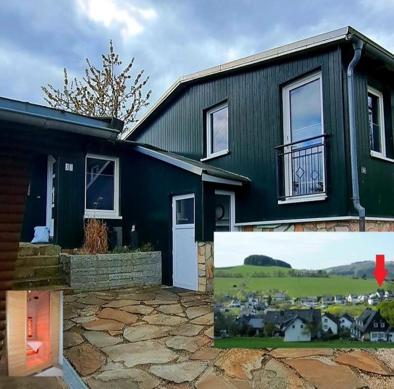 a black house with a painting of a city at Chalet Auszeit in Olsberg