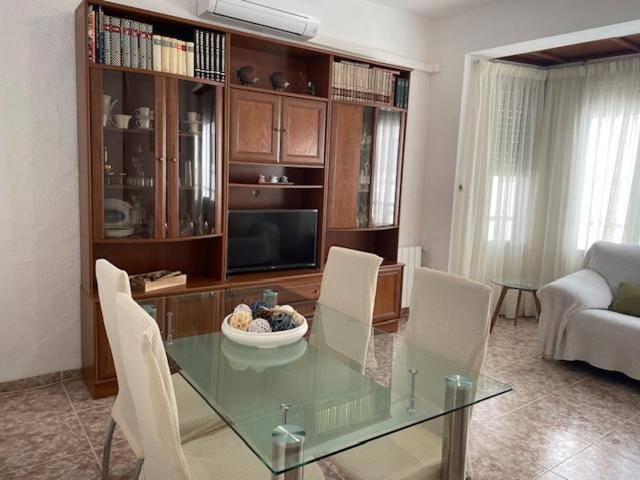 uma sala de estar com uma mesa de vidro e cadeiras em Casa Gloria 2 em Les Cases d'Alcanar