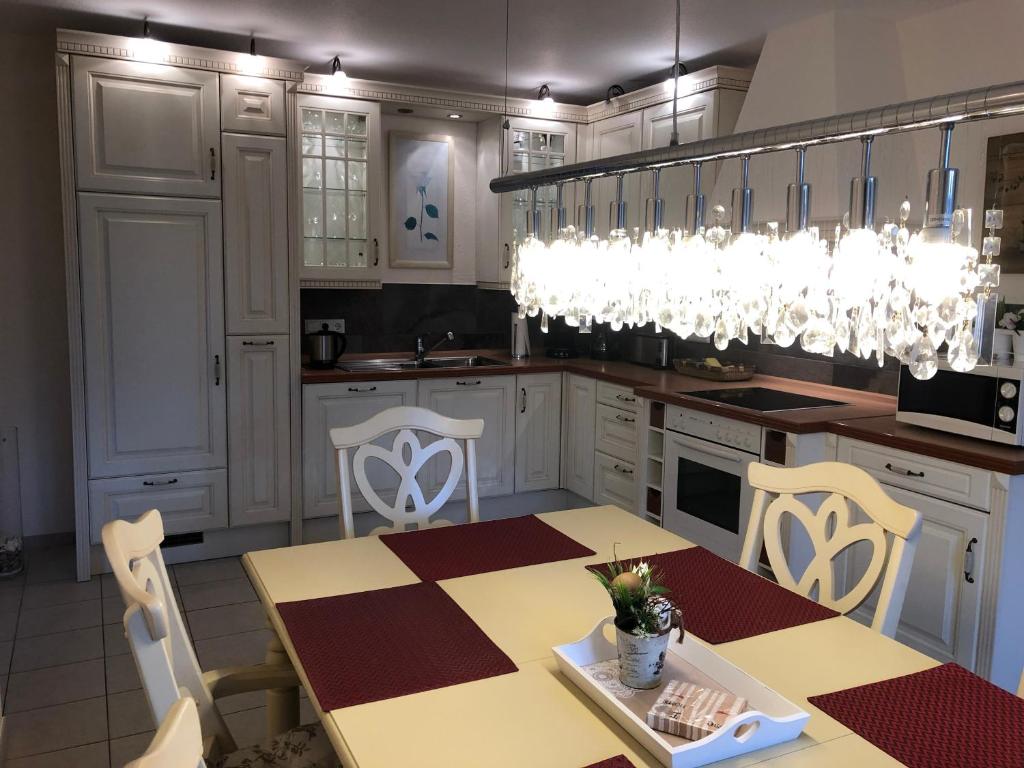 Upgant-SchottにあるFerienhaus Mare Frisicumの白いキャビネットとテーブルと椅子のあるキッチン