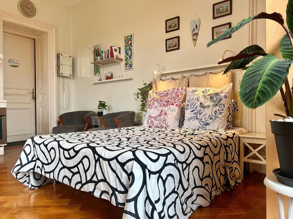 1 dormitorio con 1 cama con edredón blanco y negro en Carla’s Résidences Studio Hyper Centre, en Aix-les-Bains