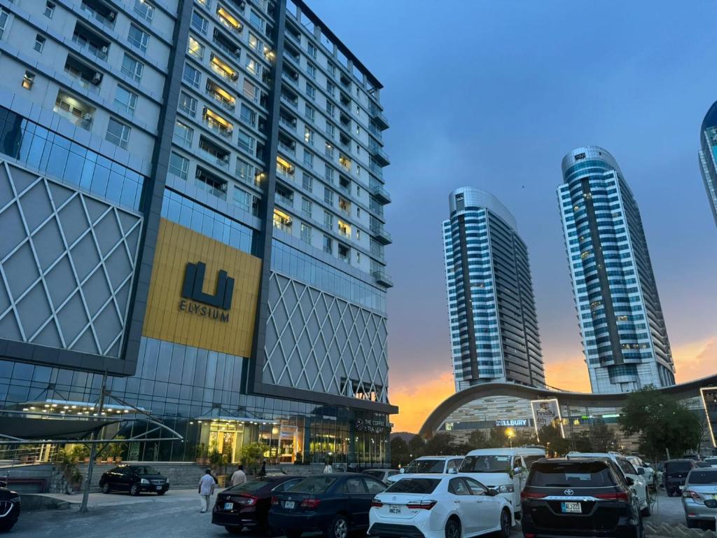 a parking lot in front of two tall buildings at LMY Elysium Designer Luxury Apartments Facing Centaurs Mall Islamabad in Islamabad