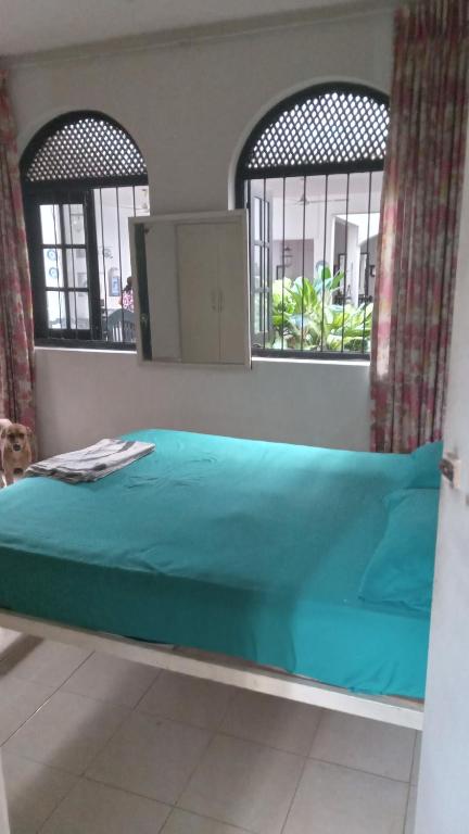 - un lit dans une chambre avec 2 fenêtres dans l'établissement Heaven Villa colombo, à Colombo