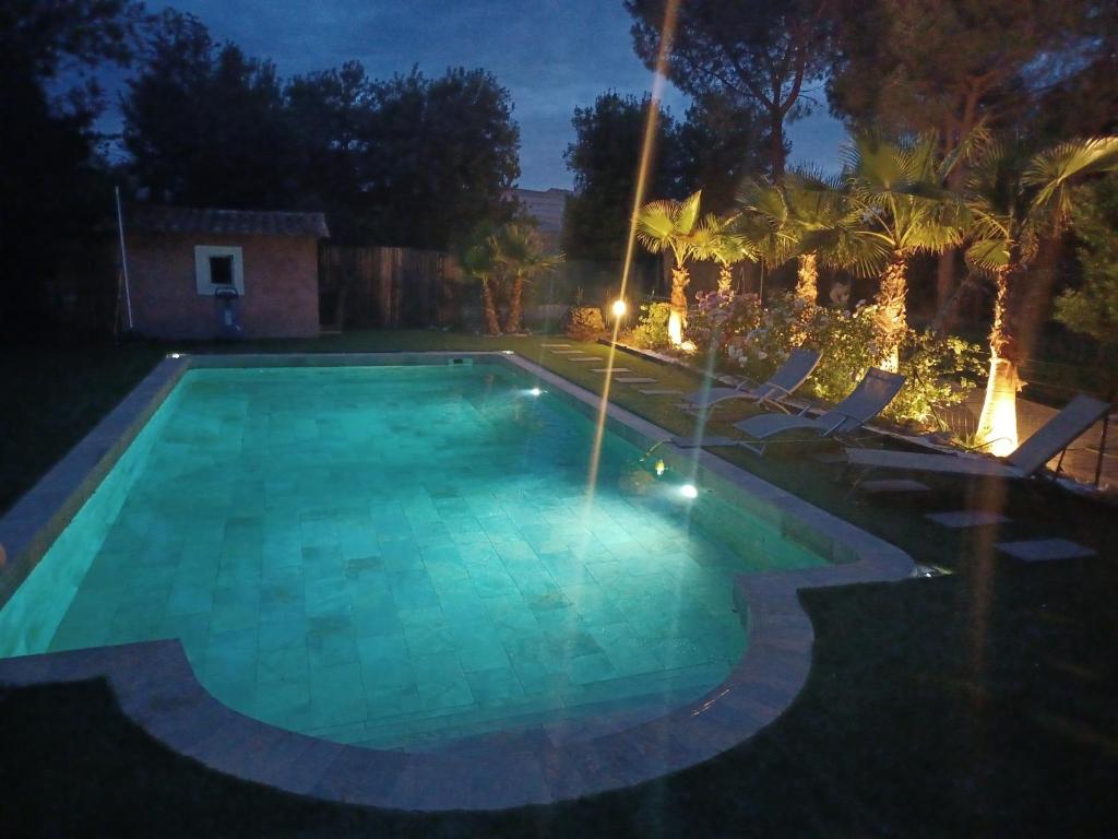una piscina illuminata di notte di Magnifique villa avec piscine 10x5 m sur 1800m2 de terrain avec parking privatif cuisine recente equpee 3 chambres dont 2 parental au rdc avec wc separe pas de vis à vis terrain de petanque bbq climatisation jeux enfants a Sérignan