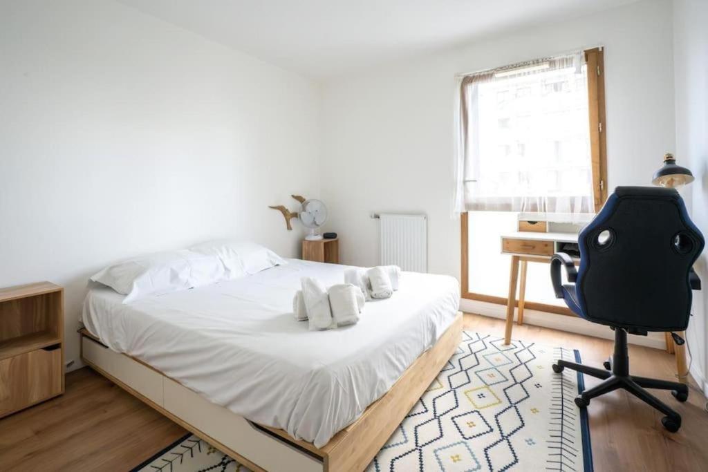 une chambre avec un lit, un bureau et une chaise dans l'établissement Spacieux appartement - Stade de France, à Saint-Denis
