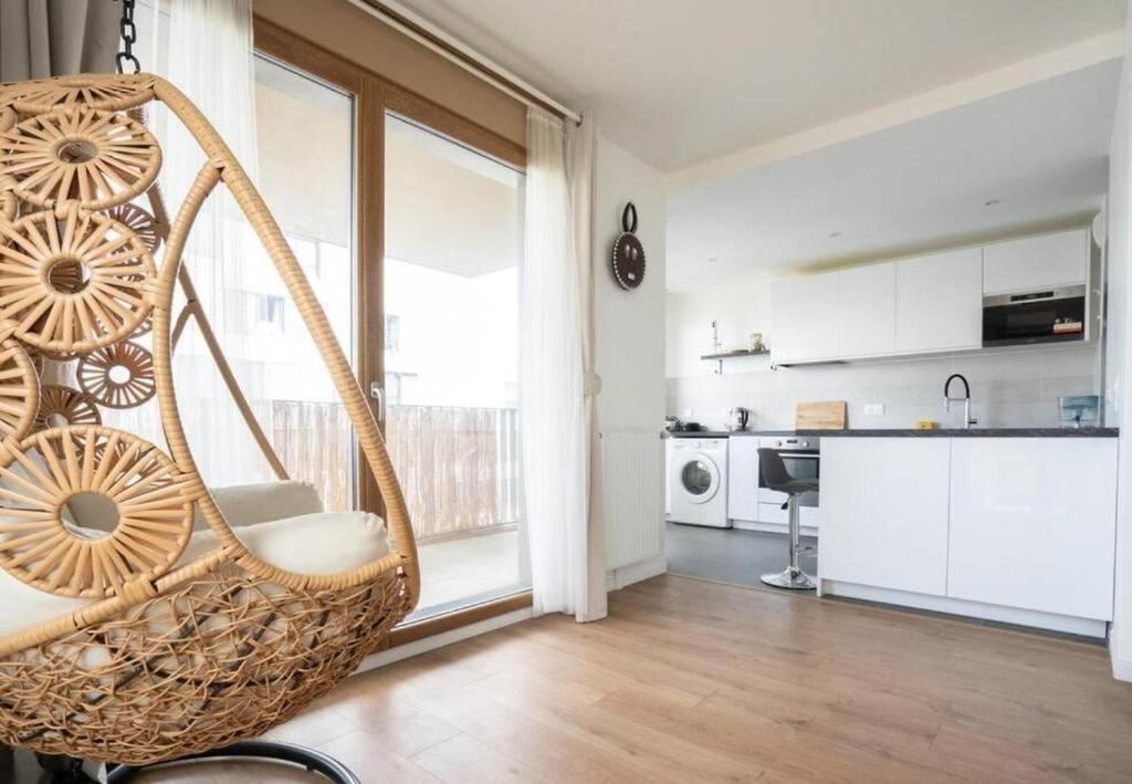 einen Schaukelstuhl in einem Wohnzimmer mit einer Küche in der Unterkunft Spacieux appartement - Stade de France in Saint-Denis