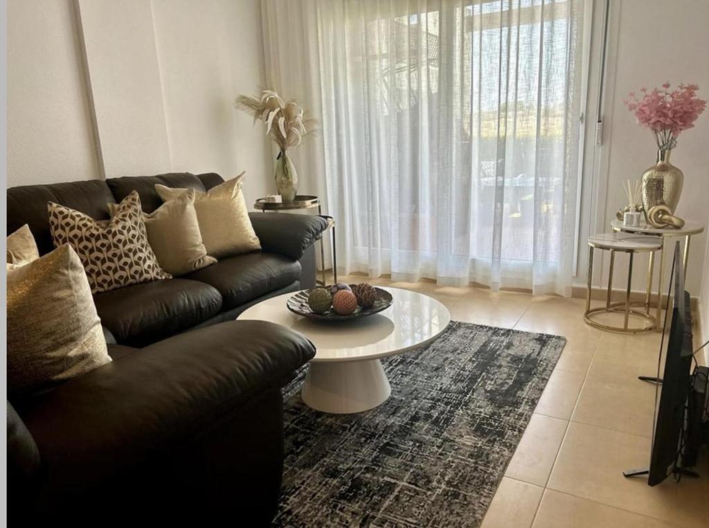 ein Wohnzimmer mit einem Sofa und einem Tisch in der Unterkunft Impeccable 2-Bed Apartment in Alhama de Murcia in Alhama de Murcia