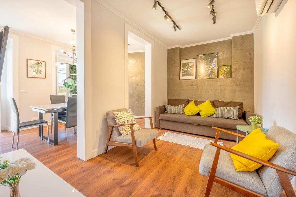 ein Wohnzimmer mit einem Sofa und einem Tisch in der Unterkunft GuestReady - Lemon House with Private Garden in Lissabon