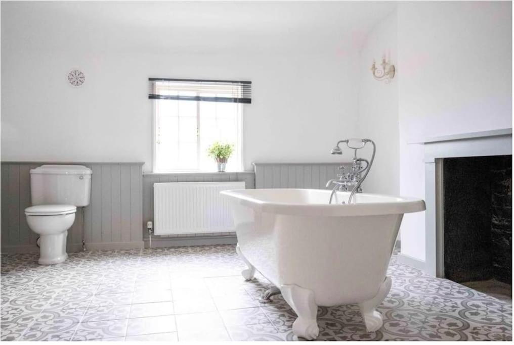 a bathroom with a white tub and a toilet at Chester City Centre townhouse in Chester
