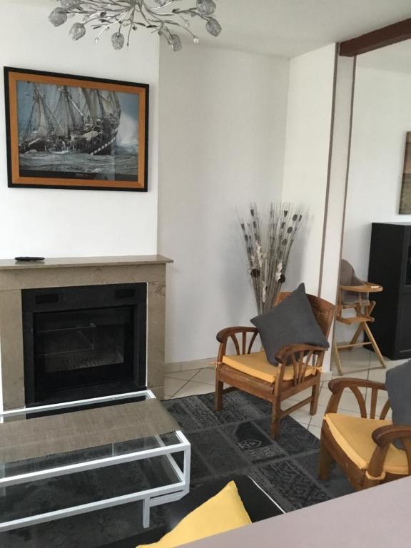 - un salon avec une cheminée et des chaises dans l'établissement Location petit fort philippe maison 5 personnes 2 chambres, à Gravelines