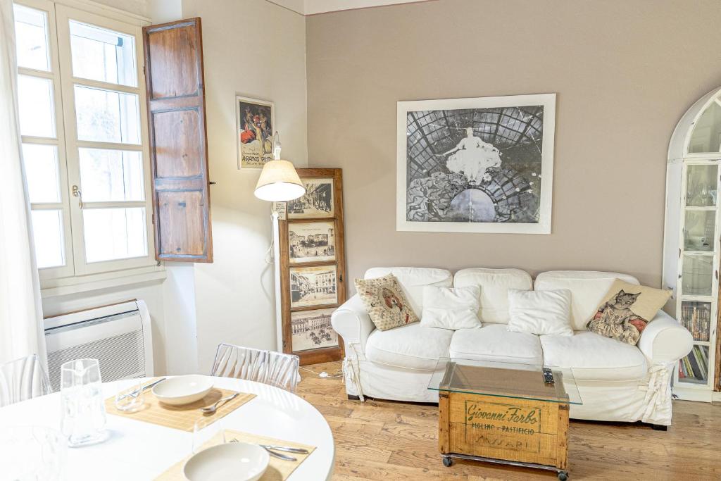 ein Wohnzimmer mit einem weißen Sofa und einem Tisch in der Unterkunft La Cona boutique apartment in centro in Sassari