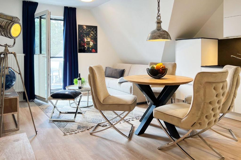 een woonkamer met een tafel en stoelen bij Düne 7 Apartment 7A 05 in Zingst