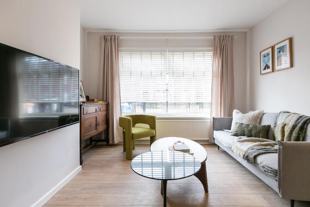 een woonkamer met een bank en een tafel bij Spacious 4 bedroom home - sleeps 8 in Manchester