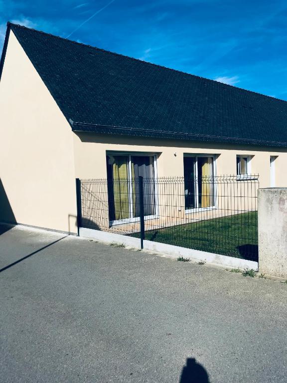 une maison blanche avec un toit noir et une clôture dans l'établissement entre terre et mer, à Saint-Pol-de-Léon