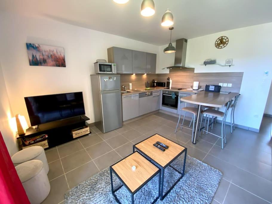 un salon avec une table et une cuisine dans l'établissement Le Balcon des Roches 5 personnes, à Gérardmer