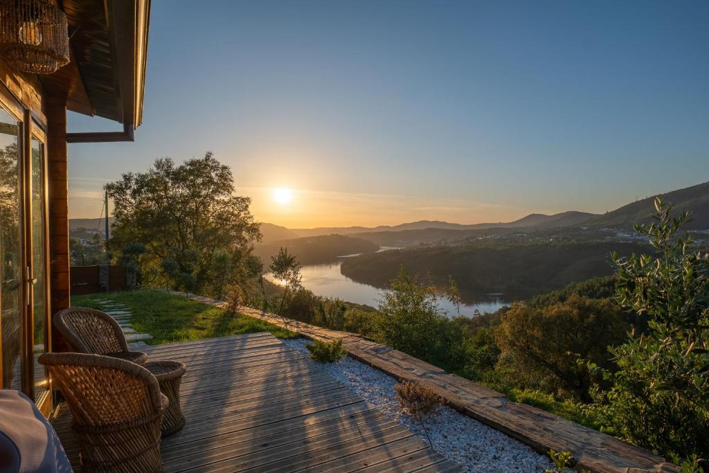 um deque com vista para um rio ao pôr-do-sol em Wood House Amazing View Douro em Raiva