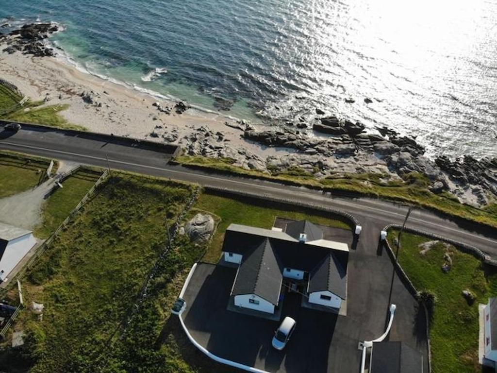 una vista aérea de una casa junto al océano en Coral Strand Lodge en Ballyconneely