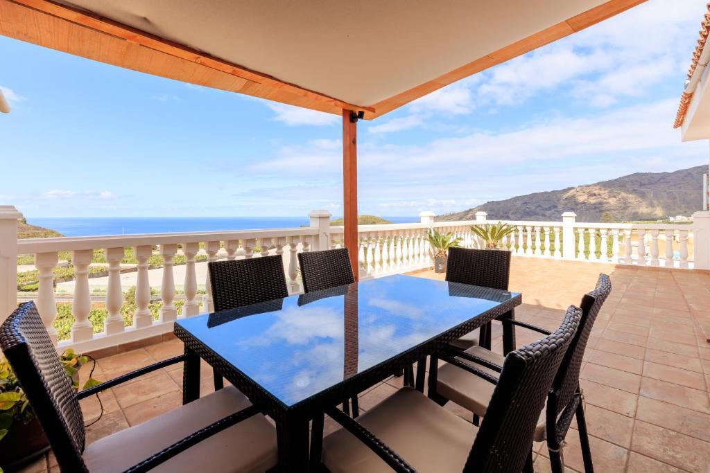 einen Tisch und Stühle auf einem Balkon mit Meerblick in der Unterkunft Casa Maravillosa - Seaview in Los Llanos de Aridane