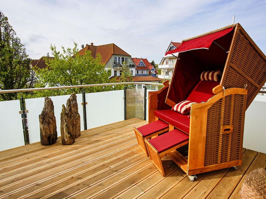 drewniany taras z krzesłem i domek dla psów w obiekcie Frauke im Anker w Zingst