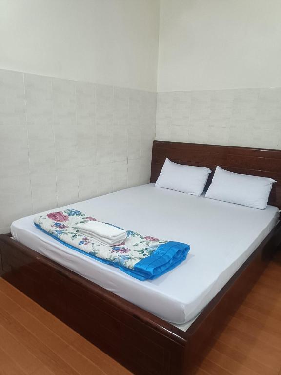 a bed with white sheets and a blanket on it at Hotel Phương linh in Ho Chi Minh City