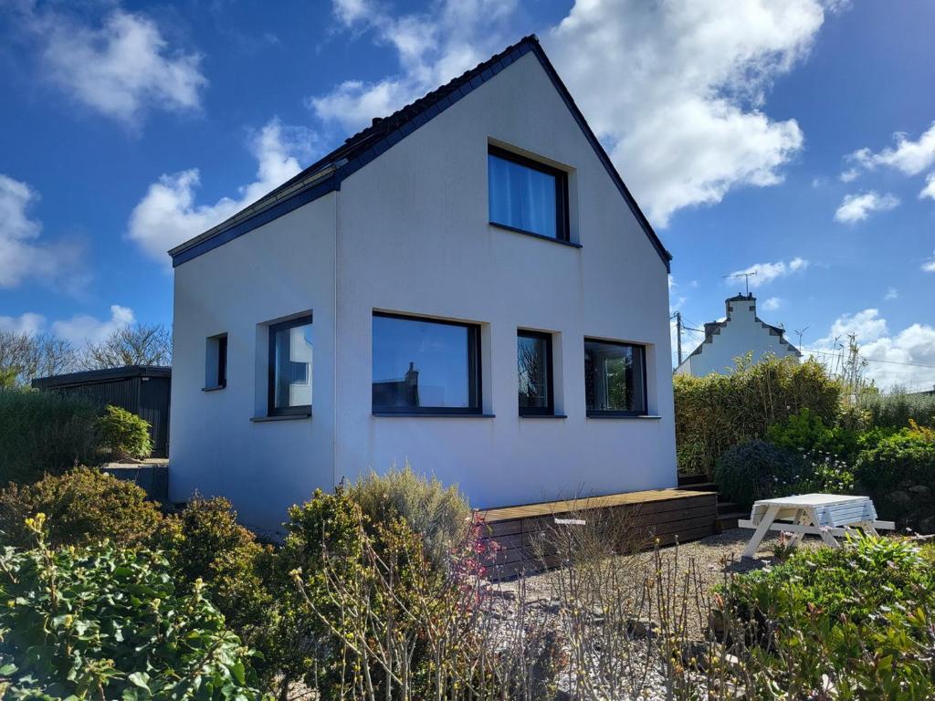 a white house with black windows at 714-Ker Tiny a 300m de la mer et du GR34 in Plouhinec