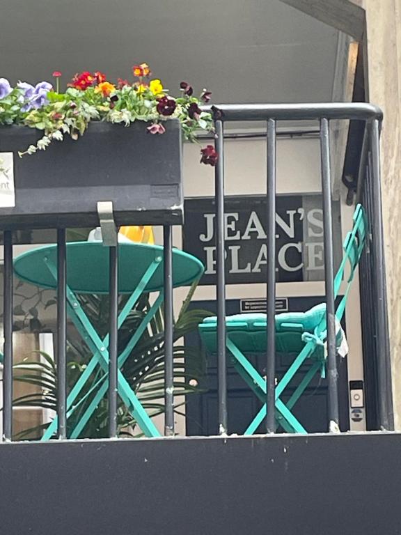 a green chair sitting next to a table with flowers at Jeans Place Watergate St Rows near racecourse in Chester