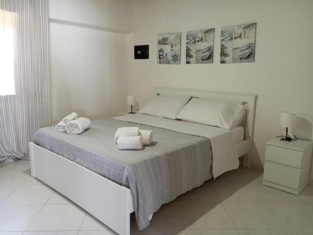 a white bedroom with a bed with towels on it at Scario house in Scario