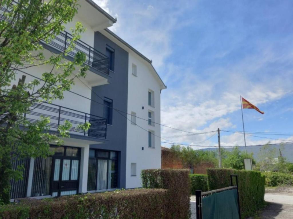 a white building with a flag in front of it at Ambient Apartments in Struga