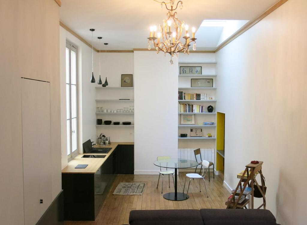 a dining room and kitchen with a glass table at Studio atypique au cœur du Bordeaux historique in Bordeaux