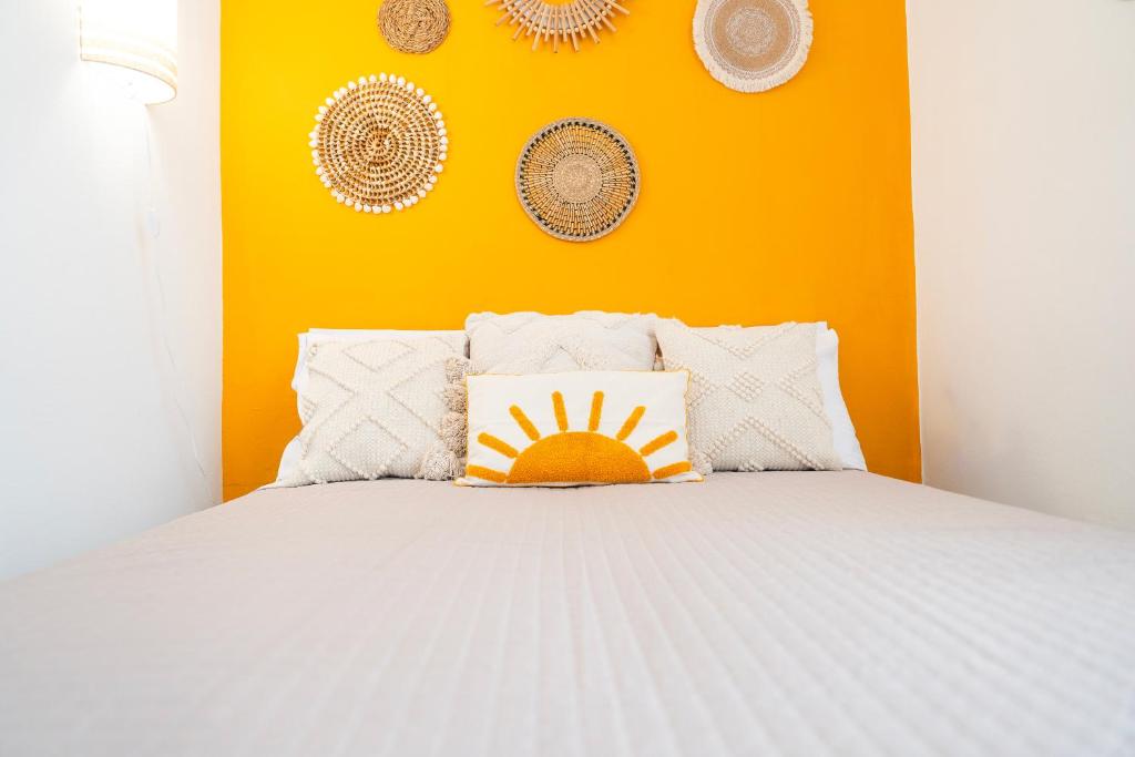 - une chambre avec un lit blanc et un mur orange dans l'établissement Luminoso appartamento vicino alle Cinque Terre (CITRA: 011015-LT-3028), à La Spezia