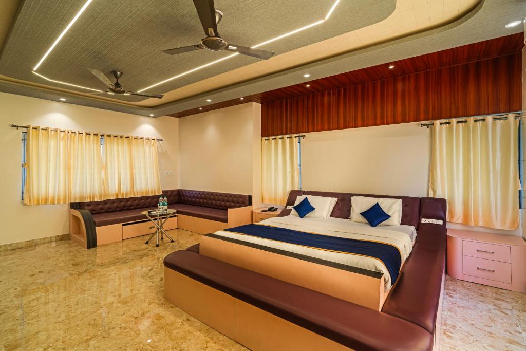 The Venue By Seasons Suites- في Dod Ballāpur: غرفة نوم بسرير كبير وأريكة