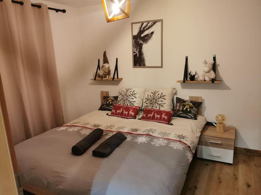 um quarto com uma cama com almofadas vermelhas em Charmant appartement balcon et parking em Lens