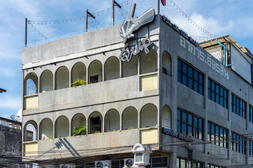 a building with a sign on the side of it at Quip Bed & Breakfast in Phuket Town