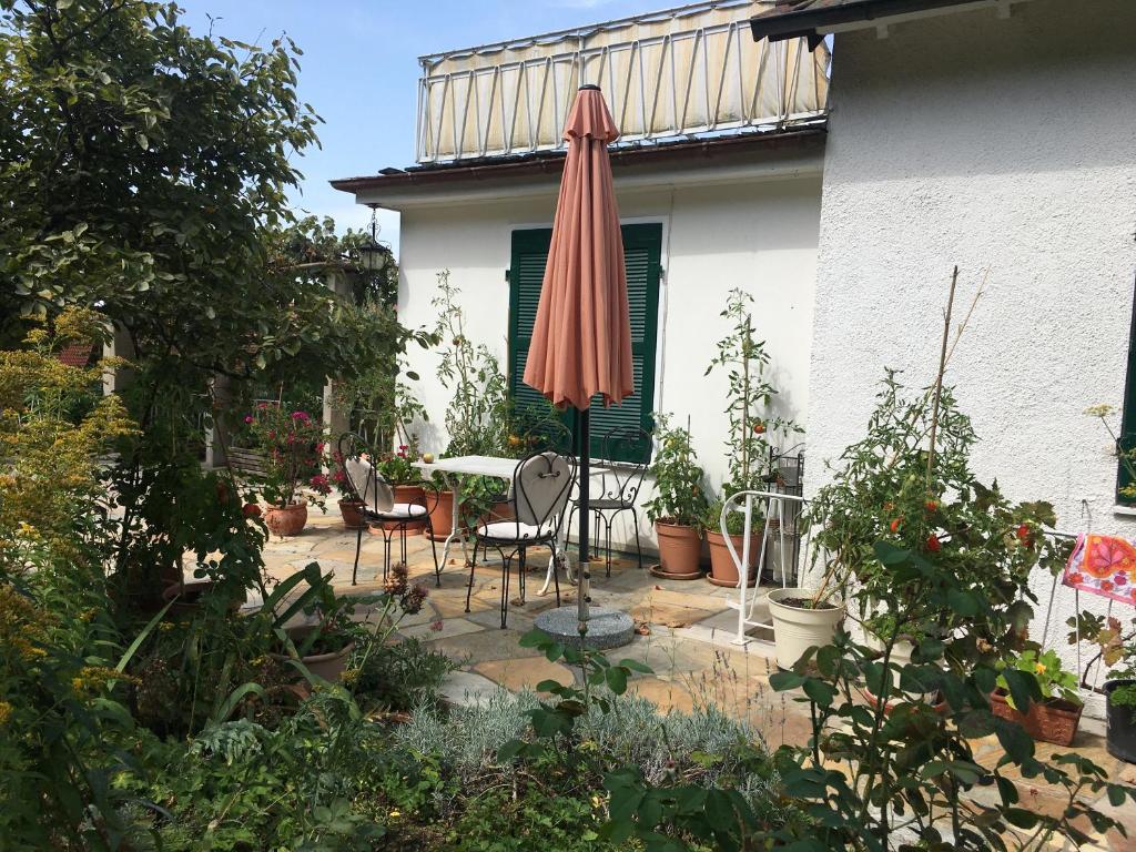 a patio with an umbrella and chairs and plants at Haus Diana in Badenweiler